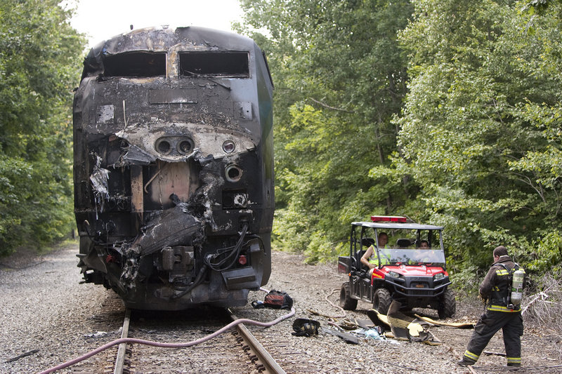 In this July 12, 2011, photo, the charred hulk of an Amtrak Downeaster engine sits on the tracks near the scene of a collision with a tractor-trailer.