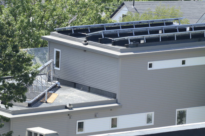 This rooftop view, taken from the nearby Portland Observatory, shows solar panels on the right and a side view of heating tubs on the left.