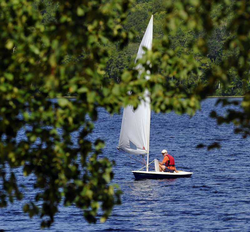 Tim Parent from Vermont sails to a beach at Donnell Pond reserve from his uncle’s camp across the lake.