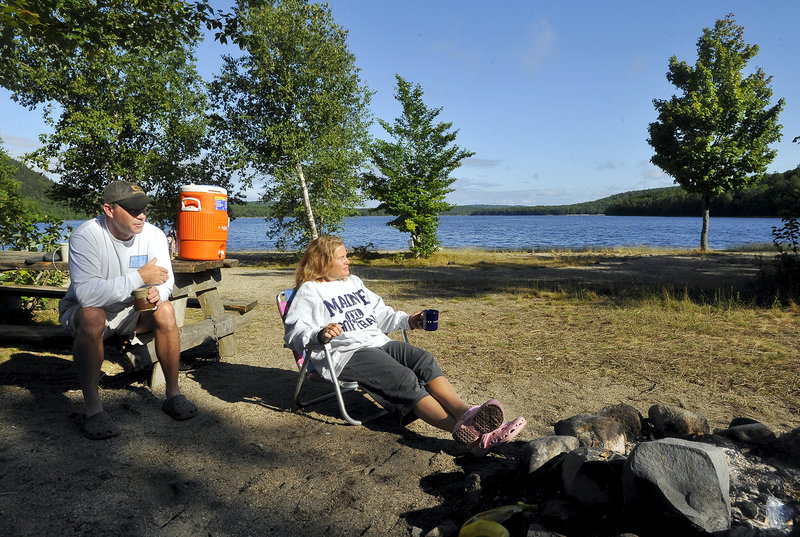 Peter and Teresa Austin of Ellsworth enjoy the early morning sunshine at their campsite at Donnell Pond, one of the state’s 37 public reserved lands.