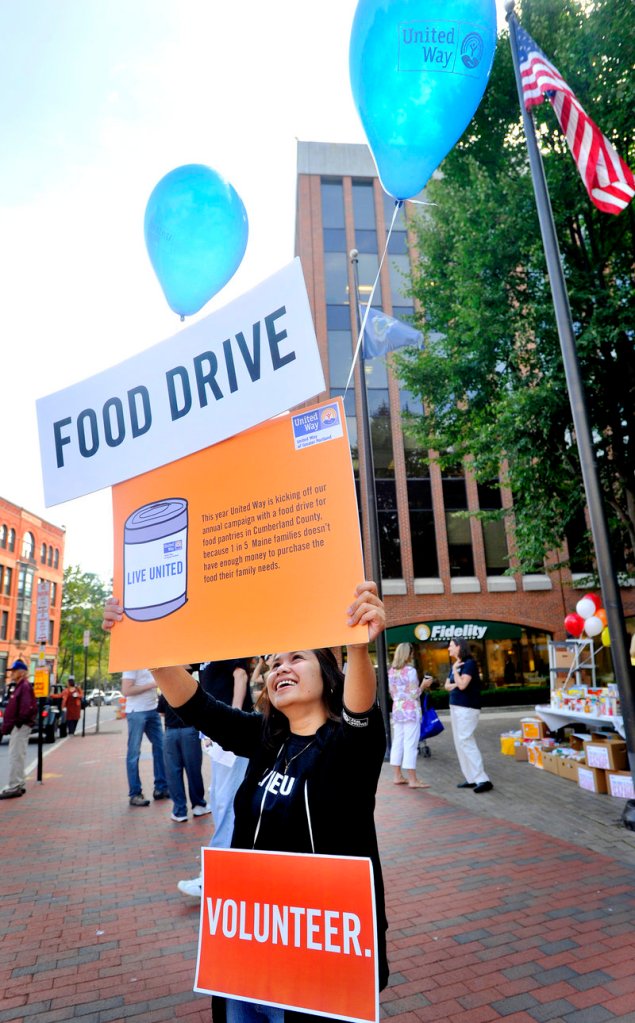 Madge Gardo, a United Way volunteer from Gorham Savings Bank, urges passers-by to donate as the Greater Portland United Way kicked off its annual campaign with a food drive at Canal Plaza in Portland on Thursday. Cumberland County was hit this year by a loss of $143,000 in federal funds for the Emergency Food and Shelter Program.