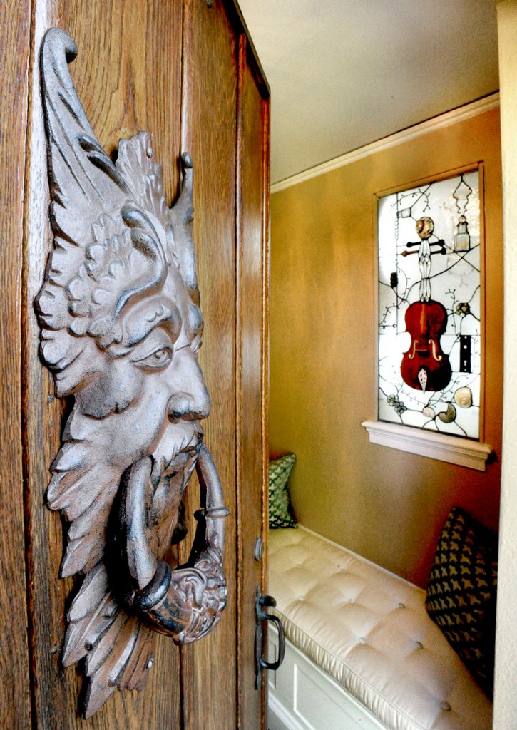 In the home’s grand foyer, a piece of art by Laura Fuller of Fuller Glass in Portland hangs in a window catching light. It’s stained glass imbedded with found objects, including antique bottles and a door lock and key, as well as the body of a violin.