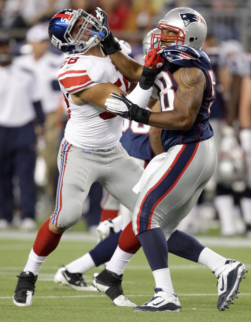 Tracy White, right, of the Patriots tangles with Mark Herzlich of the Giants during a kickoff Thursday night at Foxborough, Mass. The teams completed the exhibition season, with New York rallying for an 18-17 win.