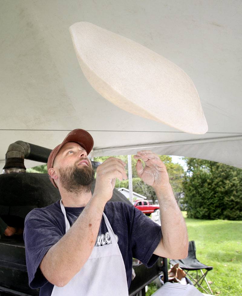 Bennett Collins, owner of Harvest Moon Pizza, hand-tosses his dough and tops his pies with organic ingredients. On this day, he had his mobile wood-fired oven stationed along Route 1B in Damariscotta.