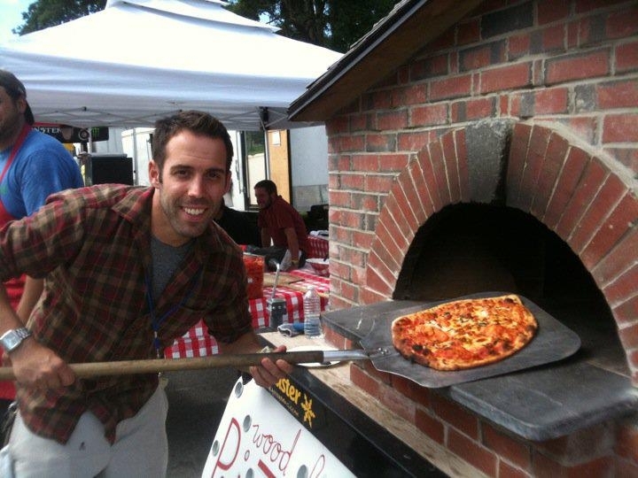Ryan Carey of Pizza Pie on the Fly removes one of his creations from his oven at the recent KahBang festival in Bangor.