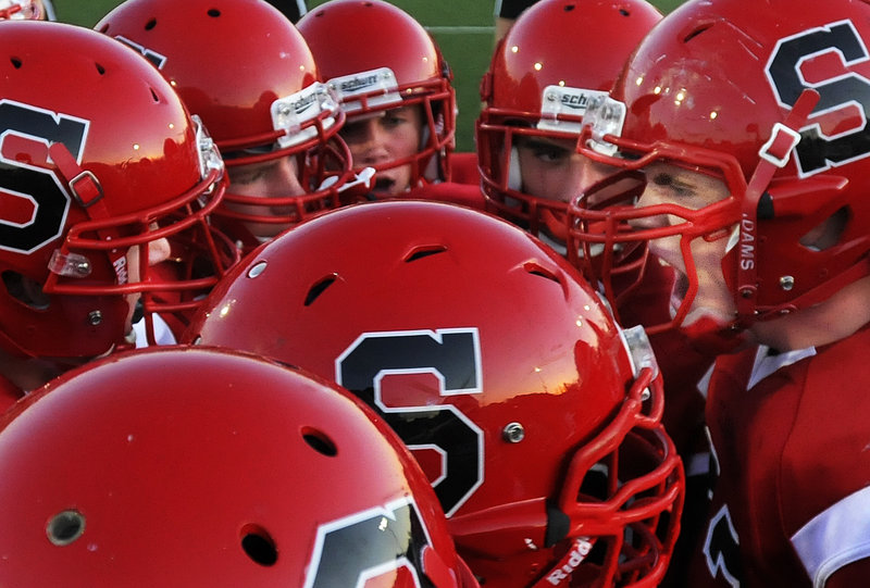 Scarborough team captain Logan Mars, right, pumps up his teammates before the Red Storm's high school football season opener against Class A rival Windham on Friday night. Scarborough won the game, 21-6.