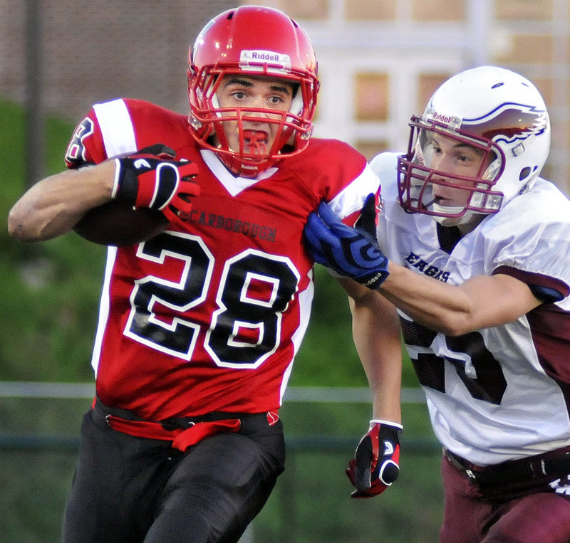 Scott Thibeault of Scarborough breaks away from Jordin Allen of Windham for a long gain in the first quarter Friday night. Thibeault finished with 274 yards on 28 carries and scored two touchdowns as the Red Storm opened with a 21-6 victory at home.