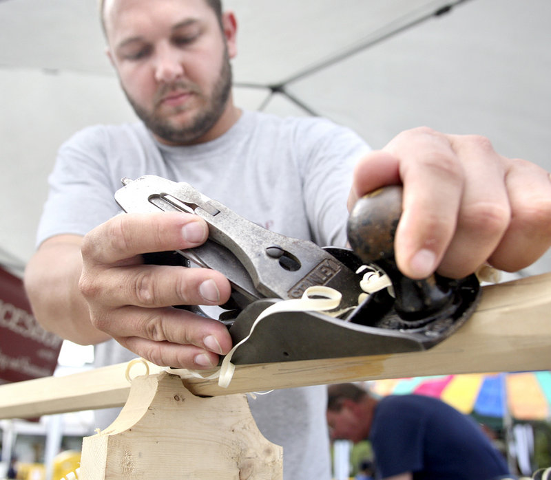 Eric Stockinger uses a plane to round an oar at a Maritime Heritage Fair booth as part of the Camden Windjammer Festival. Stockinger is executive director of The Apprenticeshop in Rockland, which teaches traditional boat-building techniques.
