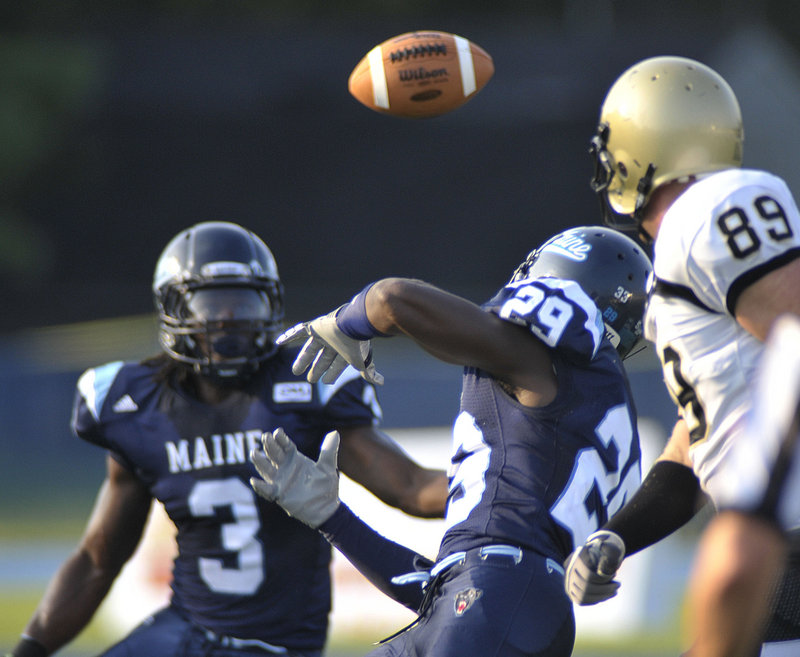 Darlos James (29) tries to knock down a pass intended for Bryant University’s Matthew Hunt, right, in the first quarter of Maine’s 28-13 victory Saturday at Orono.
