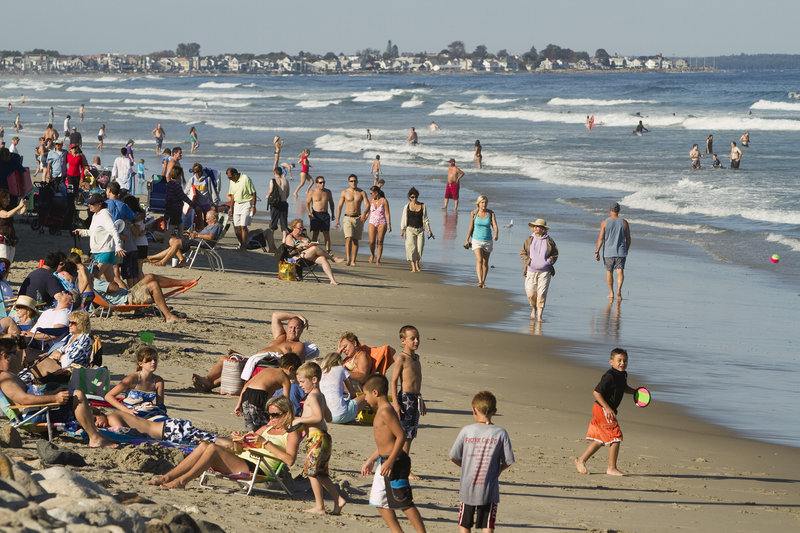 Beachgoers pack Ogunquit Beach on Friday. Maine tourism officials have reported a rise in Canadian visitors this year.