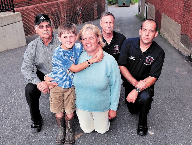 Robert Maxwell Freedom Clark and his mother, Terri Clark, pose Wednesday with Waterville firefighters Capt. Roland LaCroix, left, Robert Shay and John Gromek, who helped deliver the boy nine years ago Sunday in an alley next to the original Central Fire Station. The birth occurred on Sept. 11, 2002, a year to the minute after the World Trade Center terrorist attack.