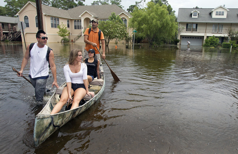 From left, Kevin Porche, Marci Ory, Aline Rodriguez and Michael Rodriguez make their way to the Rodriguez home Sunday in Slidell, La., east of New Orleans, after Tropical Storm Lee flooded the neighborhood.