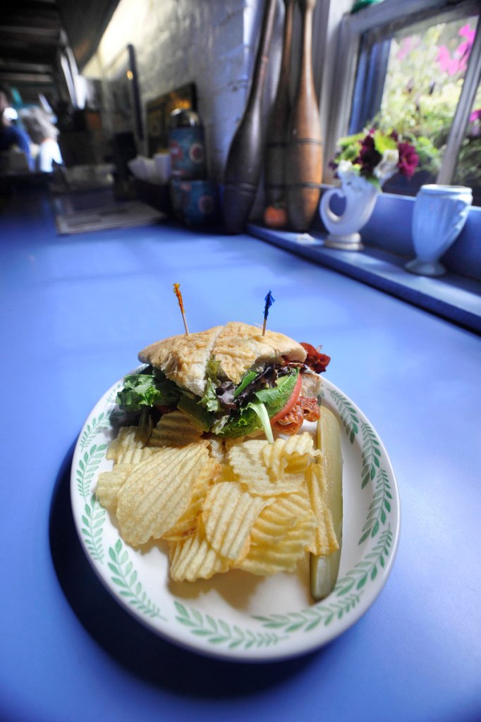 A recent luncheon special: an avocado BLT on homemade three-cheese focaccia, served with chips and a pickle.