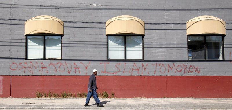 Jirde Mohamed walks past the front of the Maine Muslims Community Center on Anderson Street in Portland where graffiti had been sprayed shortly after the death of Osama bin Laden in May. "Bin Laden and Islam are different," said Mohamed, a member of the mosque who has lived in Portland 10 years.
