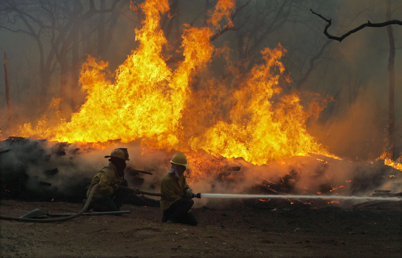 Firefighters battle a large wildfire near Smithville, Texas, on Monday. The blaze has destroyed nearly 500 homes, displaced at least 5,000 people and scorched 25,000 acres.