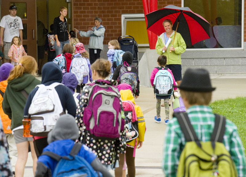 Holding an umbrella, ed tech Jill Marshall has a smile ready Tuesday for incoming Ocean Avenue Elementary students.
