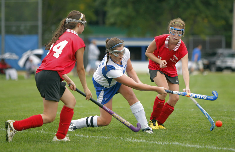 Hannah King of Kennebunk fires the ball away from Alicia Noonhester, left, and Stacey Livingston of Sanford during a Western Class A field hockey game Tuesday. Sanford, seeking a return to the playoffs this season, improved to 2-0 with a 2-0 victory on the road.