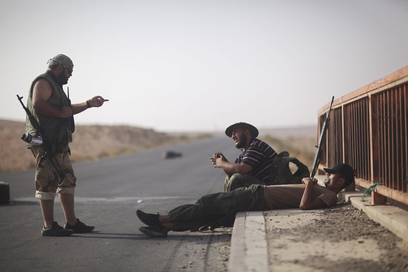 Libyan rebels chat at a checkpoint between Tarhouna and Bani Walid on Tuesday. Moammar Gadhafi is not in the convoys crossing the Sahara, the U.S. State Department said.