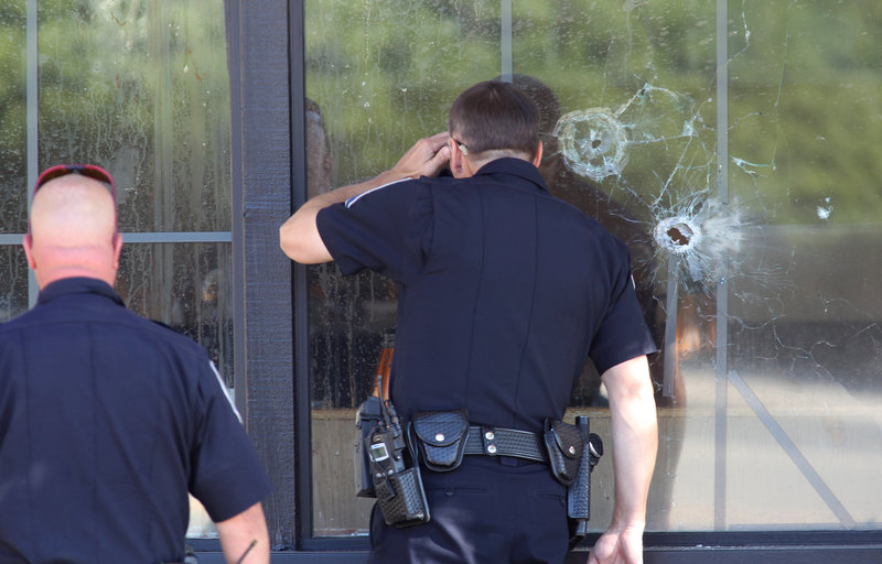 Officers look through a bullet-damaged window of an IHOP restaurant in Carson City, Nev., on Tuesday, after a gunman opened fire at the restaurant, killing two National Guard members and another person. The gunman later killed himself.