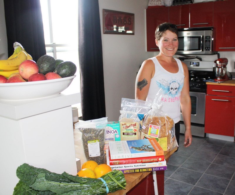 Angela May Bell stands in her Portland kitchen surrounded by some of the vegan foods she s been eating as she prepares to run the Maine Marathon.