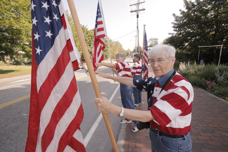 The Freeport Flag Ladies, front to back, JoAnn Miller, Elaine Greene and Carmen Footer, wave to passing motorists on Main Street in Freeport in August 2010.