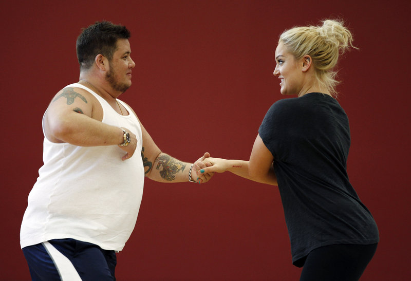 Chaz Bono, left, and Lacey Schwimmer practice dance steps while rehearsing for the upcoming season of “Dancing With the Stars,” which premieres Sept. 19. Bono is the first transgender contestant, leading some to call for a boycott of the ABC hit.