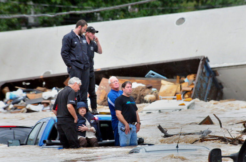 Six people stranded on the back of a pickup truck await rescue as floodwaters rise around them Wednesday in Mount Joy, Pa. Parts of New York also were inundated.