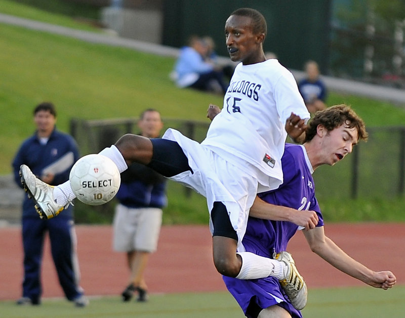 Alain Tuyishime of Portland gains leverage on the back of Billy Farrell of Deering to knock the ball away Thursday in the first half of their schoolboy soccer game at Fitzpatrick Stadium. Portland used two late goals for a 2-0 victory. Both teams have 2-1 records.