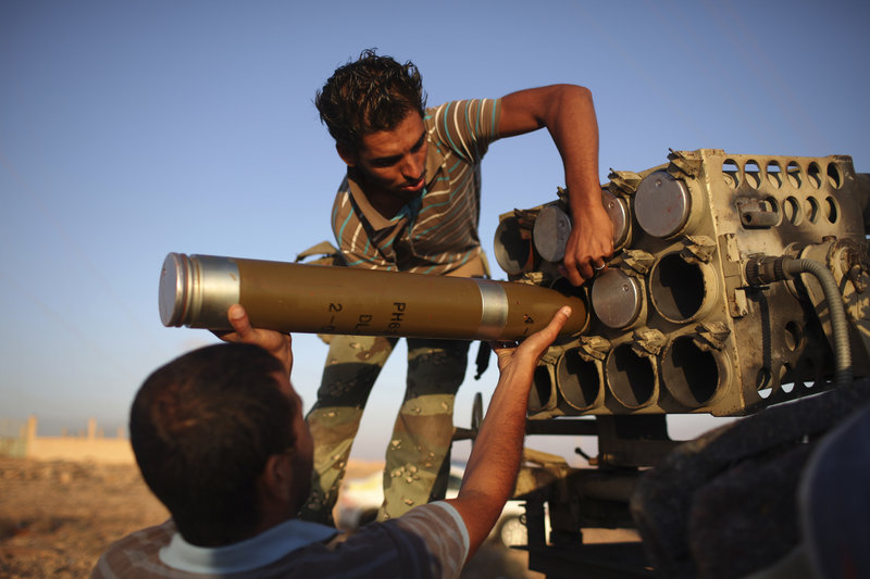 Libyan fighters prepare a projectile at a checkpoint between Tarhouna and Bani Walid on Thursday. Thousands of fighters have converged outside Bani Walid and have threatened to attack if residents don't surrender by Saturday.