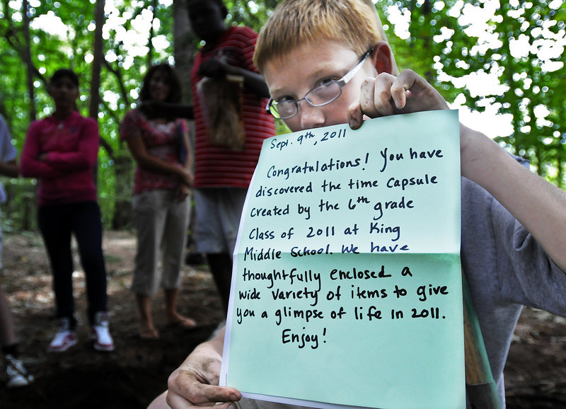 Zach Cooper, 12, a seventh-grader at King Middle School, shows off the letter he and his classmates penned for whoever finds the time capsule the class buried in Baxter Woods on Friday.