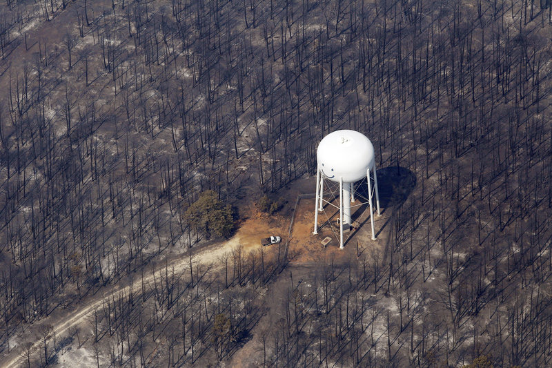 An area destroyed by wildfire surrounds a water tower Wednesday in Bastrop, Texas.