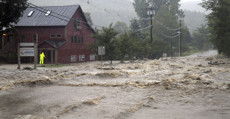 A rescuer searches a building as floodwaters from Tropical Storm Irene close the main road in Waitsfield, Vt., on Aug. 28. This scene and the one below underscore an ages-old water issue: “There’s enough quantity, but it is not always in the right places,” said a former federal water regulator.