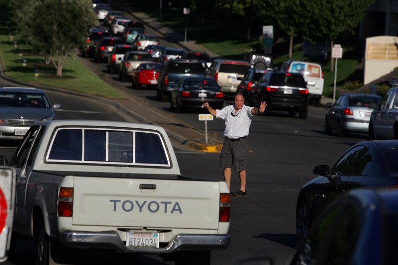 Good Samaritan Dave Eminhizer directs traffic at the intersection of Rancho Bernardo Road and Bernardo Center Drive after a massive power failure Thursday knocked out traffic lights in San Diego.