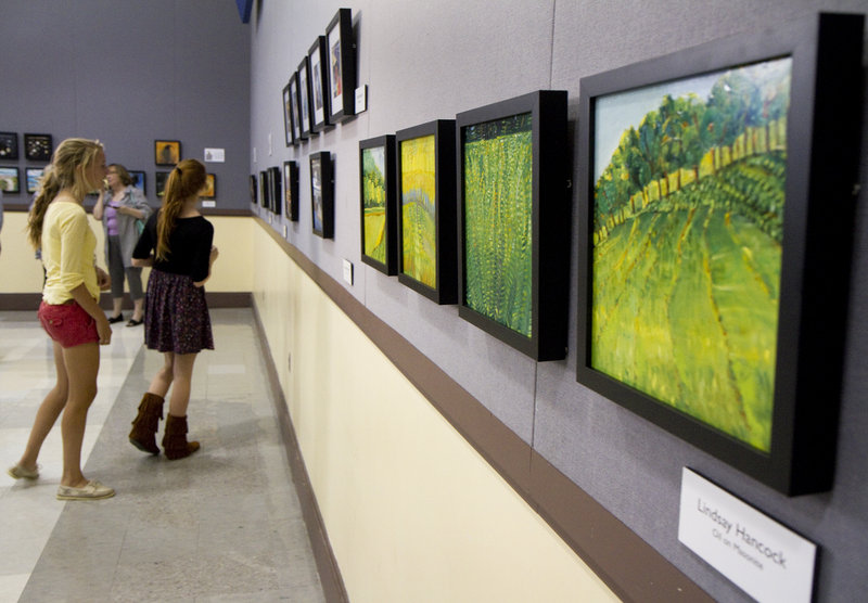 People check out the art at the Black Frame Art Sale in the Merrill Auditorium rehearsal hall Friday. The sale has been going on for eight years, organized by the Bayside Neighborhood Association.
