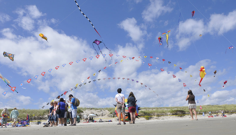 Beachgoers admire the kites in flight on Saturday during the Capriccio Festival of Kites in Ogunquit.