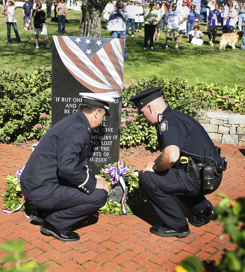 Lt. John Brooks of the Munjoy Hill Fire Station, left, and Kevin Haley of the Portland Police Department lay a wreath at the 9/11 Memorial at Fort Allen Park on the Eastern Promenade in Portland on Sunday.