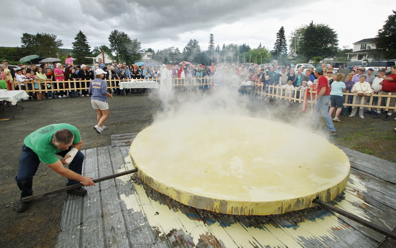 Volunteers cook what they say is the world’s biggest ploye during the Fort Kent Ploye Festival on Aug. 12. Fifty pounds of locally made dry mix are churned into 20 gallons of water to make the buckwheat pancake.