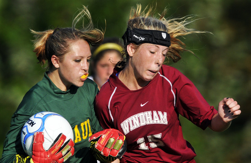 Gabe Souza/Staff Photographer Mc Auley keeper Molly Miller secures the ball while fighting off Windhams Mary Margaret Green during their SMAA girls soccer game Monday in Portland. Windham won, 3-0.