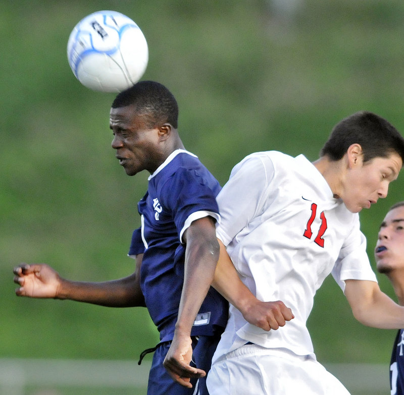 Tony Yekeh of Portland gets a head on the ball while jousting with Scarborough’s JD Herrman during a game Tuesday night at Scarborough. The teams tied, 0-0.