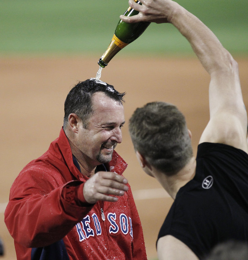 Tim Wakefield, left, gets a champagne soaking from teammate Jonathan Papelbon after recording his 200th career win in Boston’s 18-6 victory over the Blue Jays at Fenway Park Tuesday night.