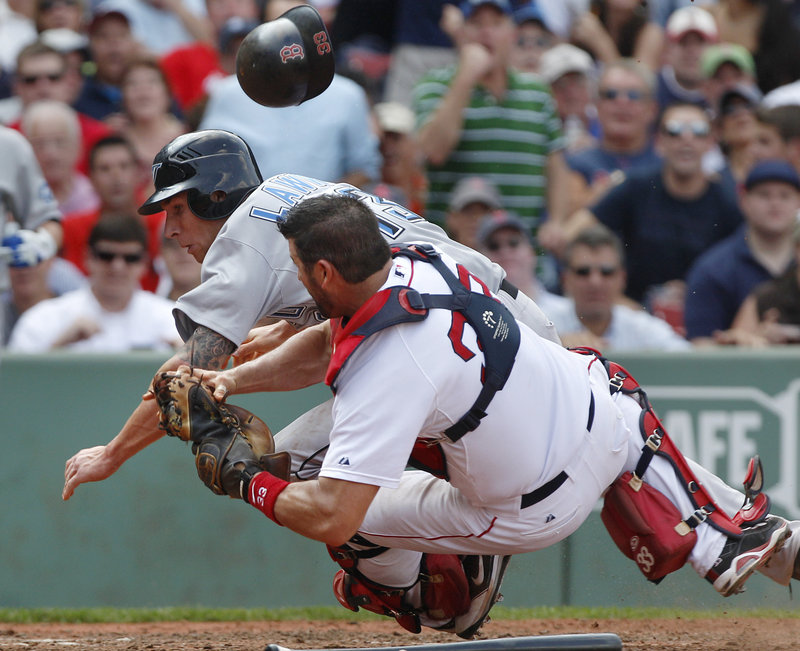 Jason Varitek holds the ball for the out Wednesday after a collision with Brett Lawrie of the Blue Jays, trying to score on a grounder. Toronto rallied to win, 5-4.