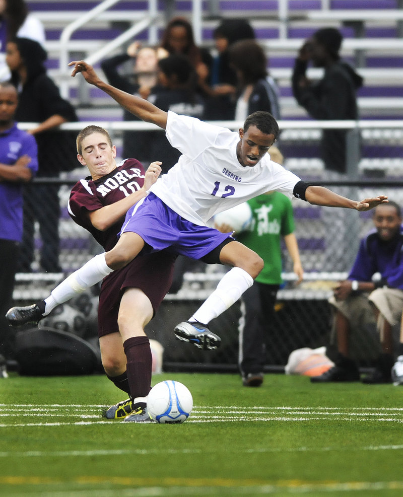 Abdirizaq Hassan of Deering competes for the ball Thursday night against Jake Emard of Noble during their schoolboy soccer game. Deering won 2-0 at home in its first outing since one of its players, Mohamed Hassan, drowned last weekend.