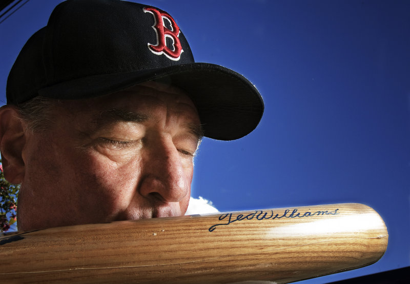Bud Elwin kisses a bat signed by Ted Williams. A longtime supporter of Healthy Kids Damariscotta, Elwin is raffling off memorabilia to help the nonprofit after a loss of state funding.
