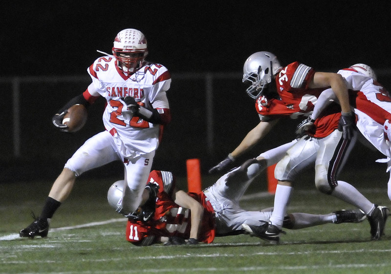 Alex Shain, who scored three touchdowns for Sanford, eludes one tackle and looks for more room in the game at South Portland.