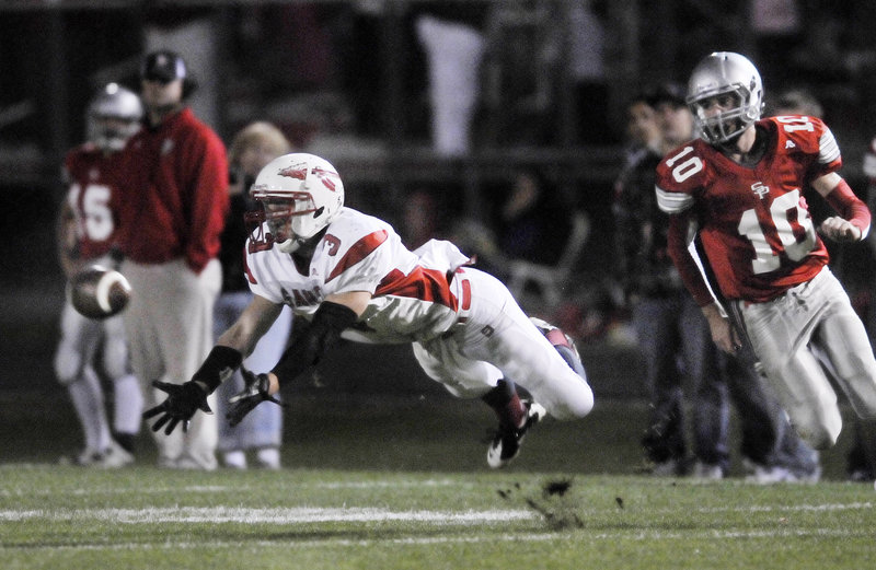 Jon Schroder of Sanford dives in an attempt to make a catch Friday night as Michael Salvatore of South Portland moves in on defense. South Portland came away with a 42-34 victory in a Western Class A game.