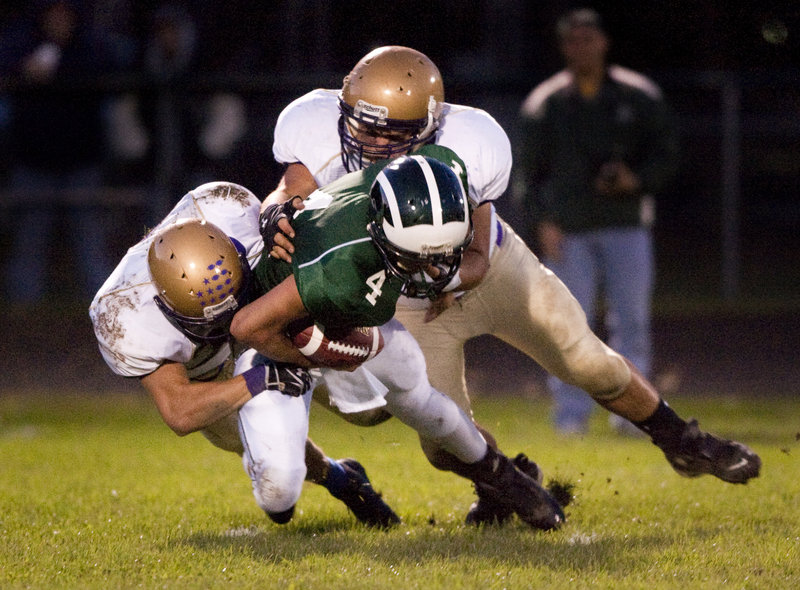 Tyson Goodale of Bonny Eagle finds no escape from linemen Donald Goodrich, left, and Charlie Rainville of Cheverus in the first quarter of Cheverus' 42-18 victory in a Western Class A football game Friday night.