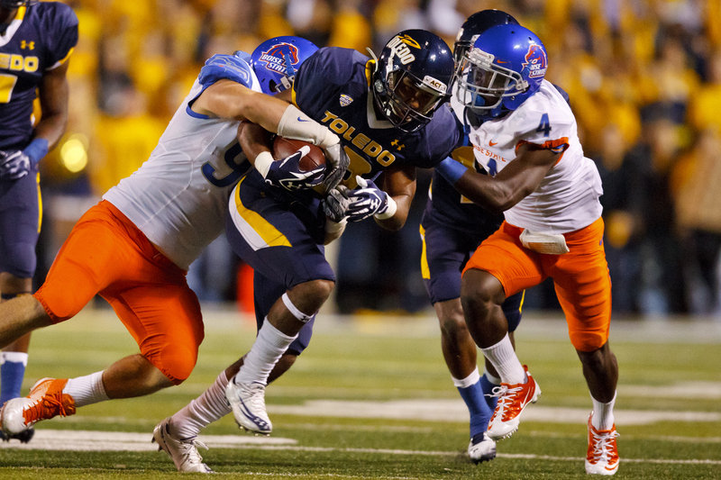 Eric Page of Toledo, center, is tackled by Boise State’s Byron Hout, left, and Jerrell Gavins after a reception Friday night. Fourth-ranked Boise State won, 40-15.