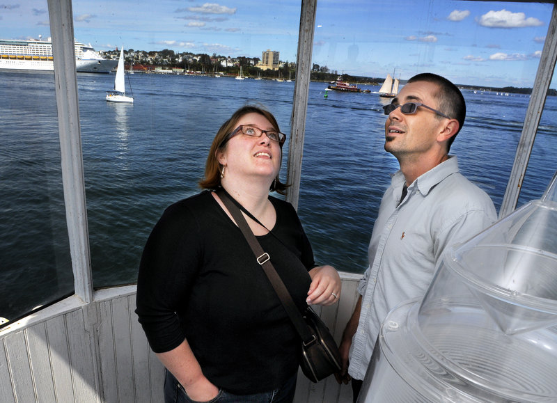 Bronwyn and Sean Dougherty of Oakland check out the inside of the top of Bug Light in South Portland on Saturday. A cruise ship is visible in Portland Harbor at left.