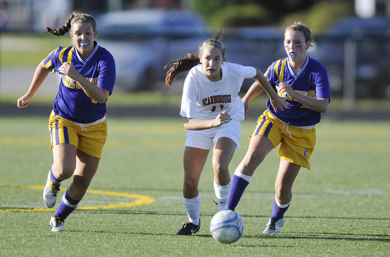 Photos by Shawn Patrick Ouellette/Staff Photographer Taylor Leborgne of Scarborough, center, attempts to get to the ball ahead of Leeann Morrison, left, and Eden Monsen of Cheverus during their schoolgirl soccer game Saturday. The teams finished in a 1-1 tie at Scarborough High.