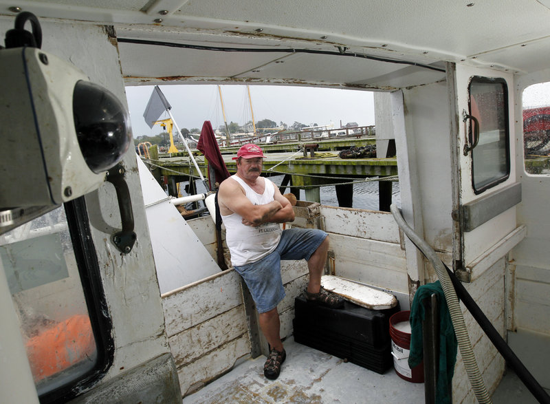 Bill Skrobacz sits on his fishing boat in Gloucester, Mass., as a camera, left, is positioned to observe him and his crew as they work. He volunteered to test the system.